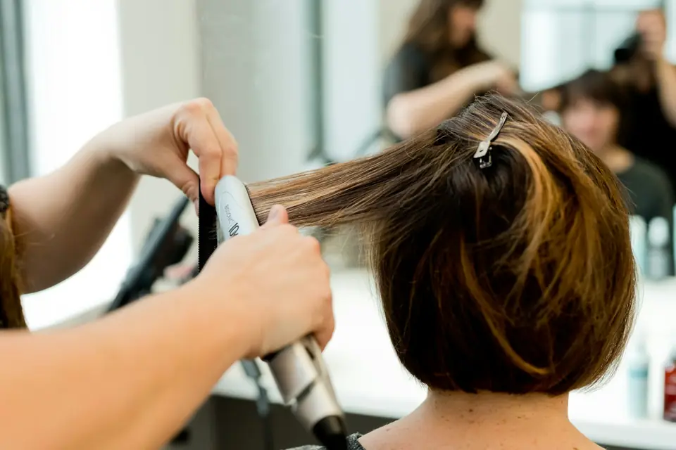 Stylist smoothing a client's bob with a flat iron