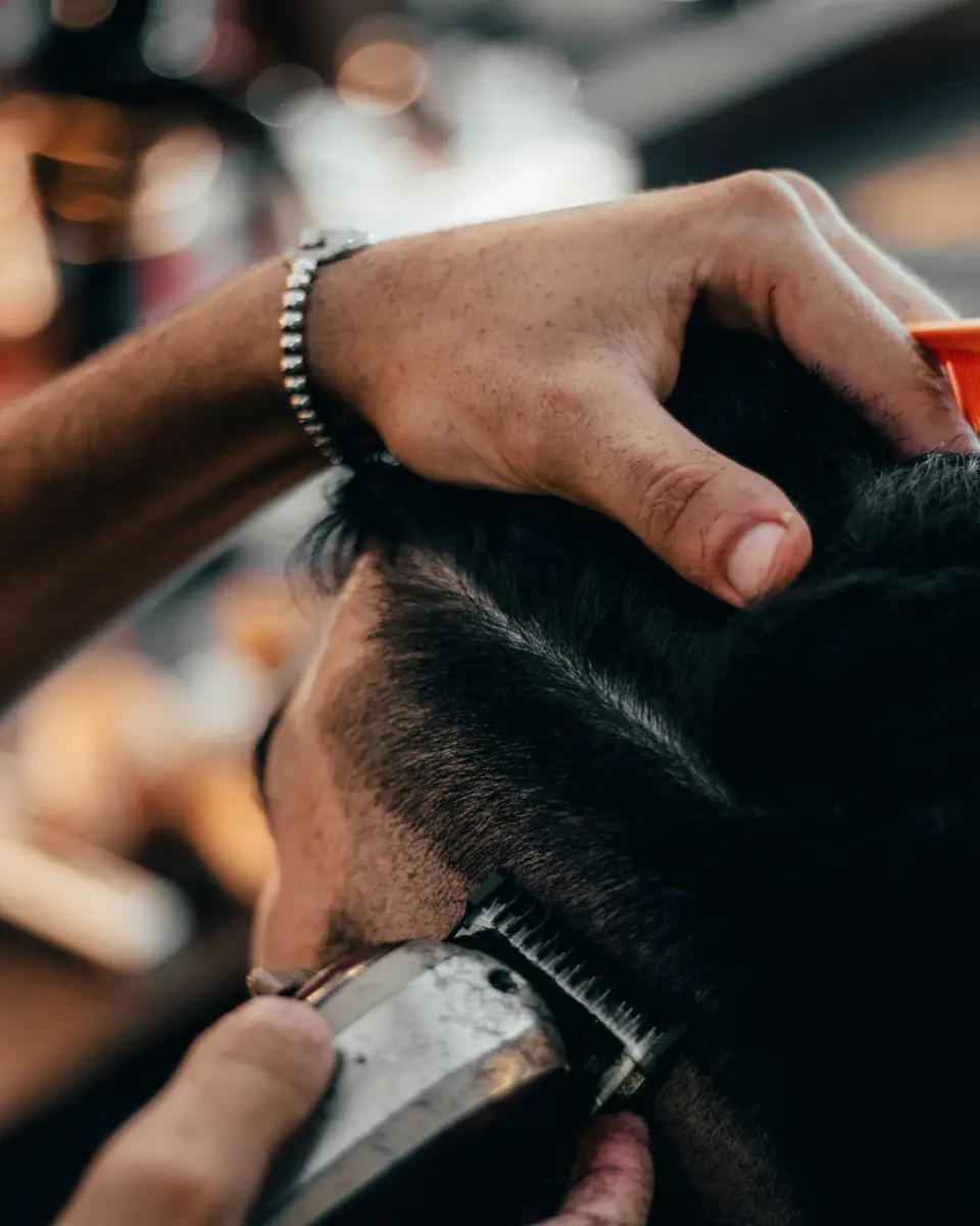 Close-up of a barber trimming a client's hair with clippers