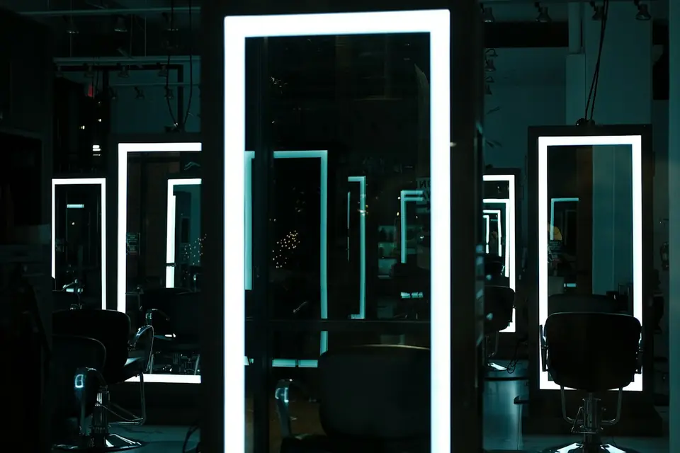 Dark salon interior with glowing mirror frames